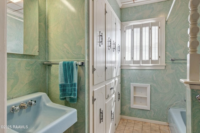 full bathroom featuring a sink, wallpapered walls, tile patterned flooring, baseboards, and a bath