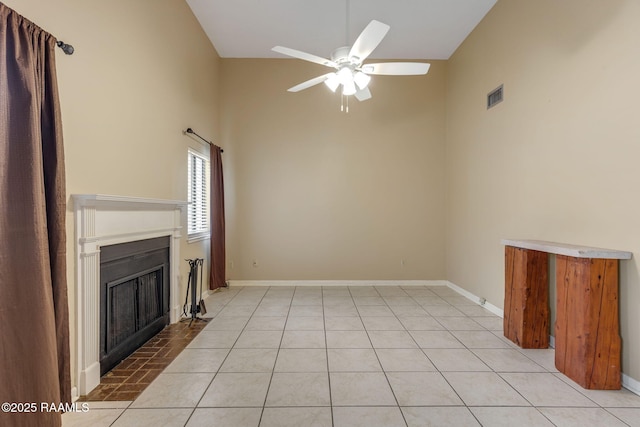 unfurnished living room with light tile patterned floors, baseboards, visible vents, a ceiling fan, and a fireplace