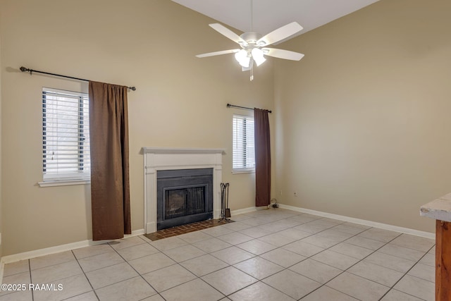 unfurnished living room featuring light tile patterned floors, baseboards, a ceiling fan, a fireplace with flush hearth, and high vaulted ceiling