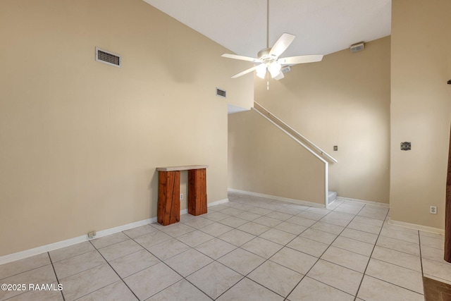 empty room featuring stairs, visible vents, a ceiling fan, and light tile patterned flooring