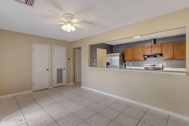 kitchen with ceiling fan, under cabinet range hood, visible vents, appliances with stainless steel finishes, and brown cabinets