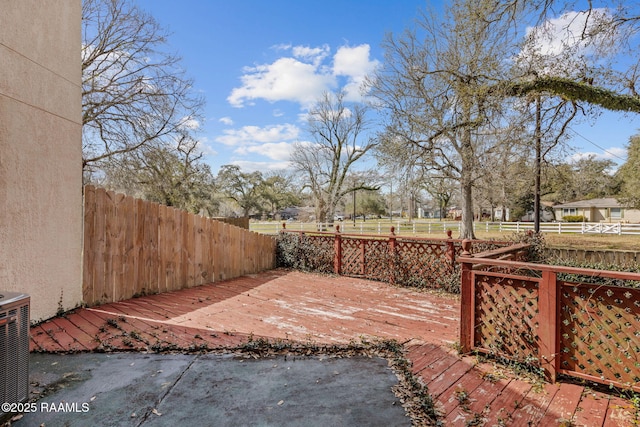 exterior space with central AC unit and a fenced backyard