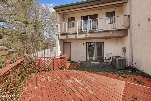 deck featuring central AC unit, a patio area, and fence