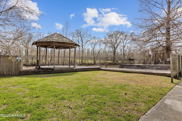 view of property's community with a deck, a gazebo, a lawn, and fence