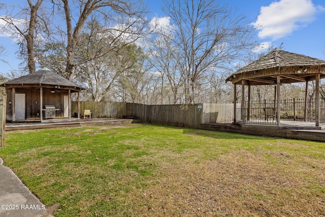 view of yard featuring a fenced backyard, a deck, and a gazebo