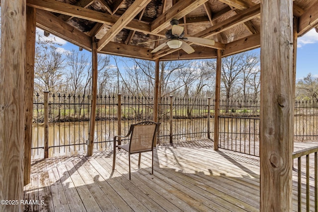 wooden terrace with ceiling fan and fence