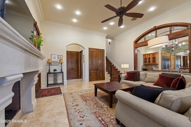 living room featuring arched walkways, crown molding, visible vents, a fireplace with flush hearth, and stairs