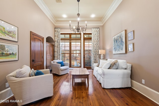 living area featuring baseboards, ornamental molding, a chandelier, and dark wood-type flooring