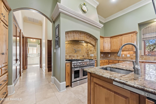 kitchen with crown molding, visible vents, a sink, light stone countertops, and double oven range