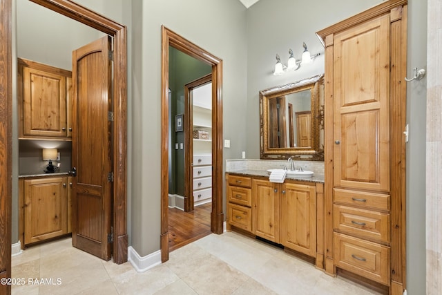 bathroom with tile patterned flooring, baseboards, and vanity