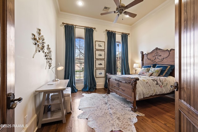 bedroom with hardwood / wood-style floors, ceiling fan, ornamental molding, and visible vents