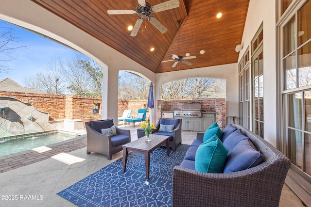 view of patio / terrace with an outdoor hangout area, ceiling fan, a grill, fence, and exterior kitchen