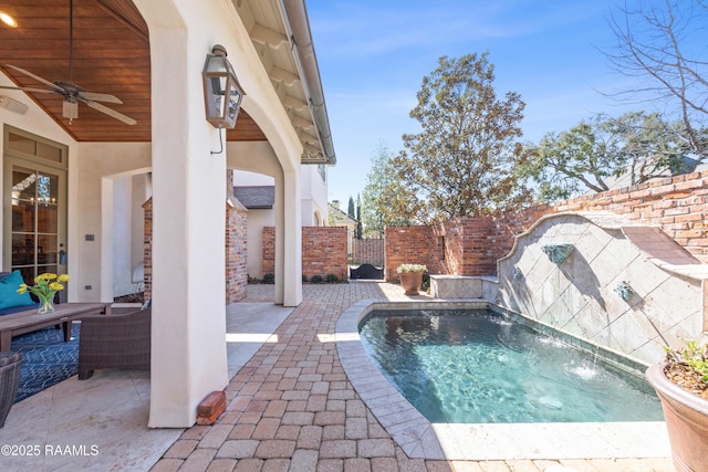 view of swimming pool featuring a patio area, a fenced backyard, and a ceiling fan