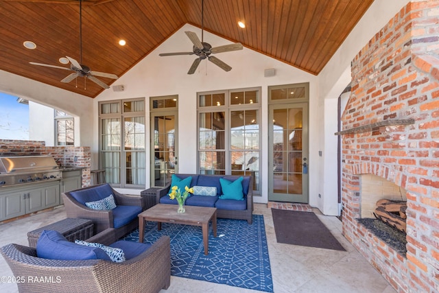 view of patio featuring exterior kitchen, a grill, an outdoor living space with a fireplace, and ceiling fan