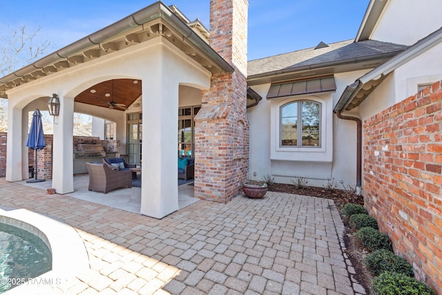 view of patio with an outdoor kitchen, outdoor lounge area, and a ceiling fan