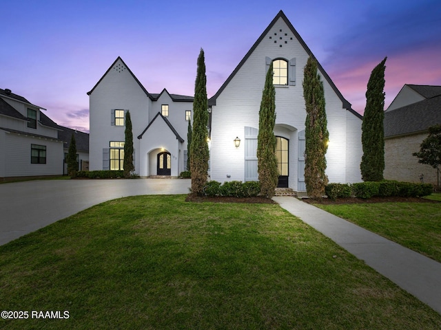 french country inspired facade featuring driveway and a front lawn