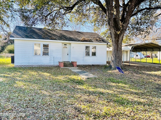 back of property featuring entry steps, a detached carport, and a yard