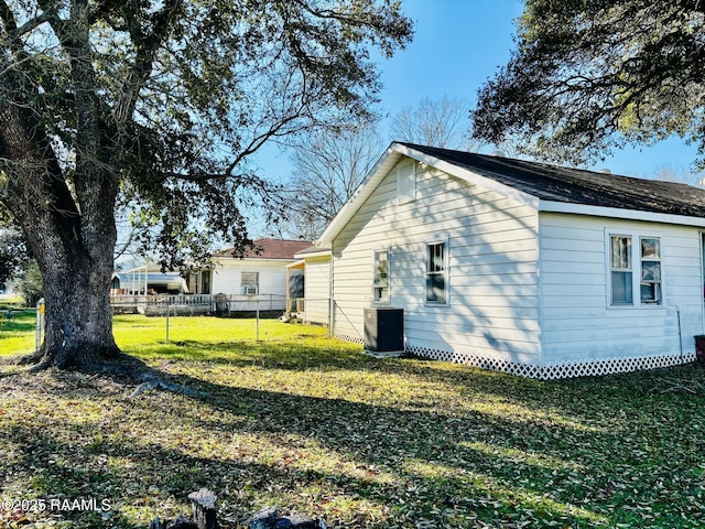 exterior space with a yard, central AC unit, and fence