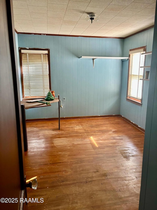 spare room with crown molding and wood finished floors