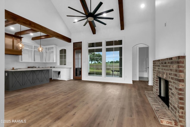 134 Cypress Bend Rd, Scott, LA 70583 - unfurnished living room featuring a brick fireplace, high vaulted ceiling, a ceiling fan, beamed ceiling, and dark wood-style flooring