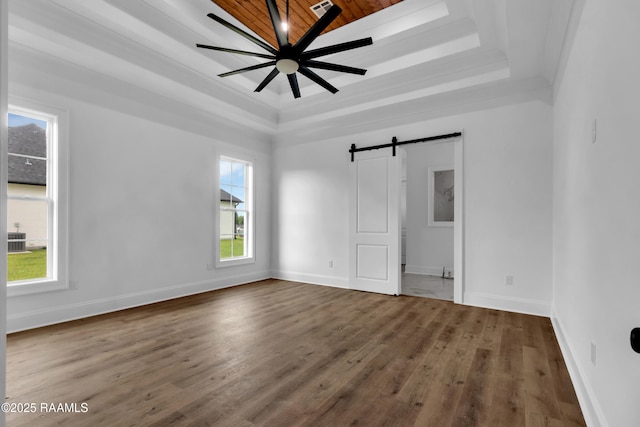 134 Cypress Bend Rd, Scott, LA 70583 - unfurnished bedroom featuring a raised ceiling, multiple windows, a barn door, wood finished floors, and wood ceiling