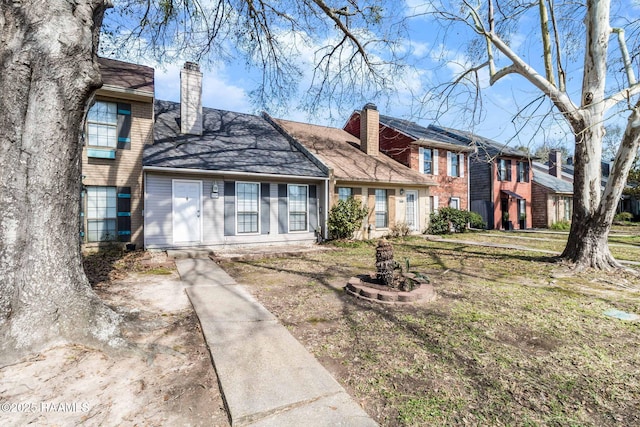 view of front of home with brick siding and a chimney