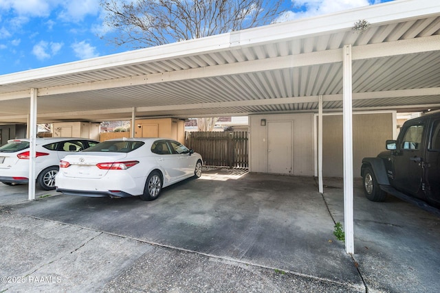 covered parking lot featuring fence