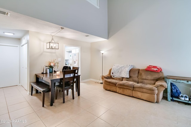 dining room featuring baseboards, light tile patterned flooring, visible vents, and a notable chandelier