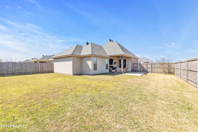 rear view of house with a patio area, a fenced backyard, and a yard