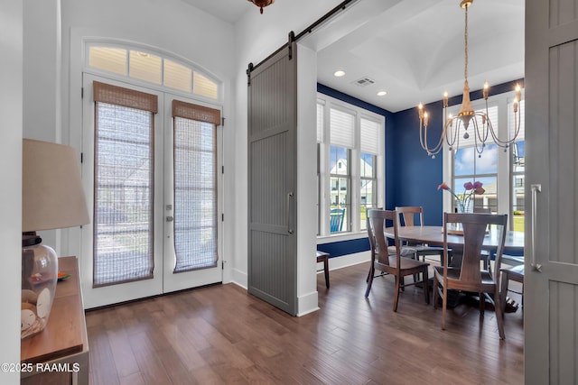 dining area featuring french doors, dark wood-style floors, a barn door, recessed lighting, and a chandelier