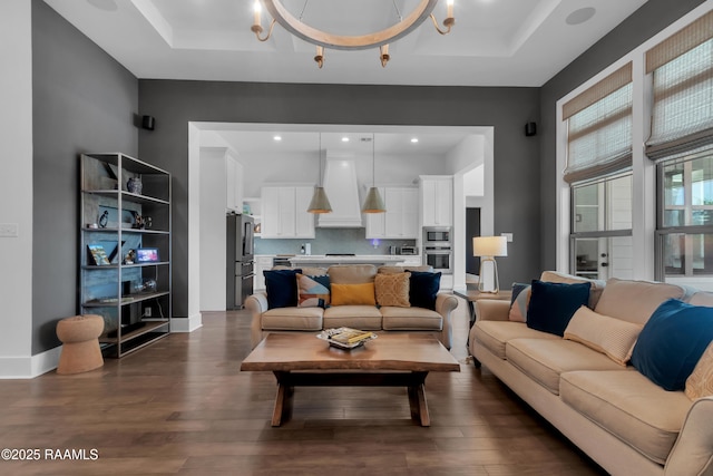 living room with dark wood finished floors and a raised ceiling