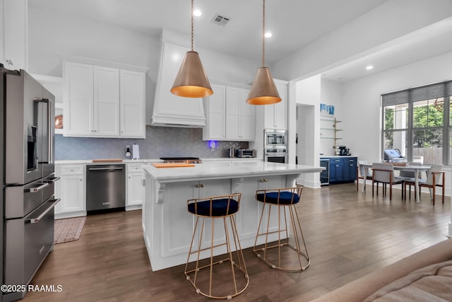 kitchen with stainless steel appliances, light countertops, visible vents, and backsplash