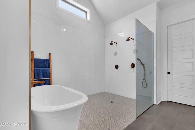 bathroom featuring a freestanding bath, vaulted ceiling, and walk in shower