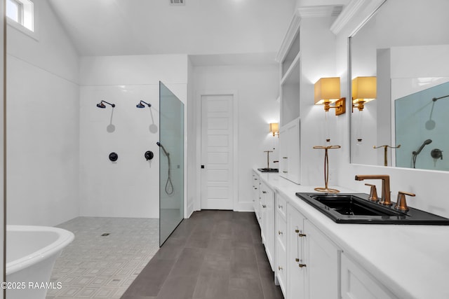 bathroom featuring walk in shower, a freestanding tub, a sink, and double vanity