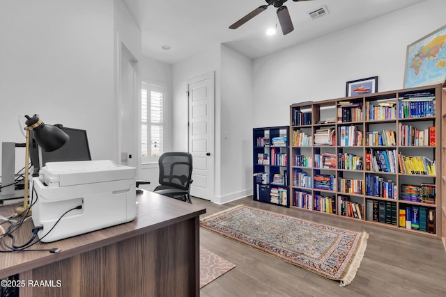office space with baseboards, wood finished floors, visible vents, and ceiling fan