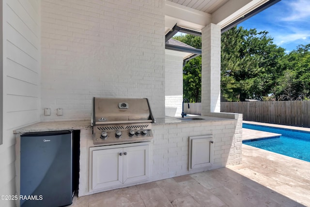 view of patio featuring a fenced in pool, a sink, area for grilling, fence, and grilling area
