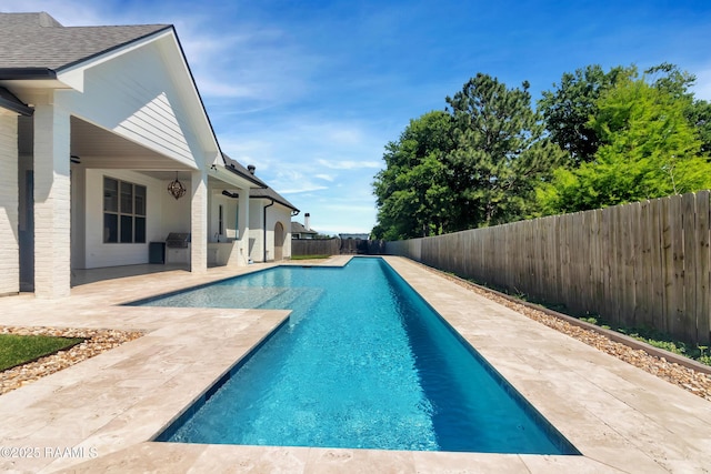 view of swimming pool with a fenced backyard, a patio, a fenced in pool, and area for grilling