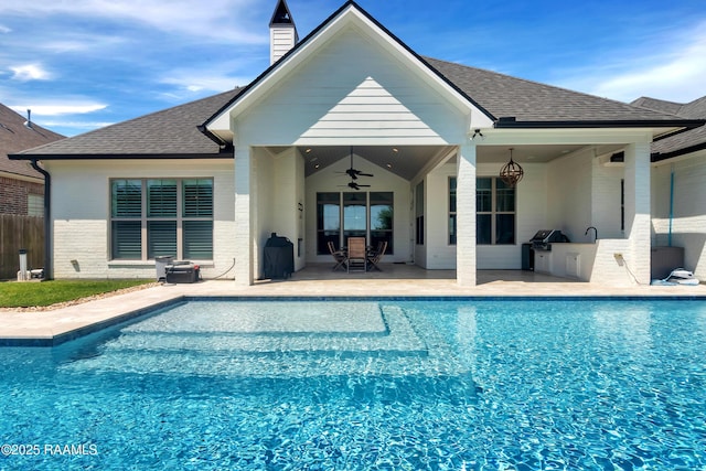 outdoor pool featuring a ceiling fan, exterior kitchen, a grill, fence, and a patio area
