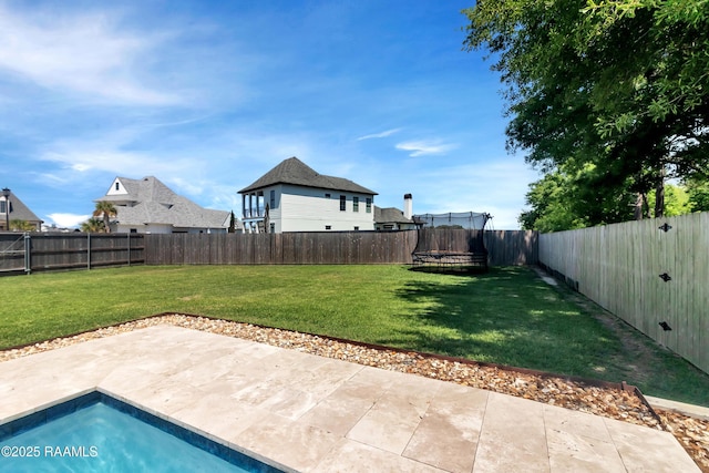 view of yard with a trampoline, a fenced backyard, and a patio