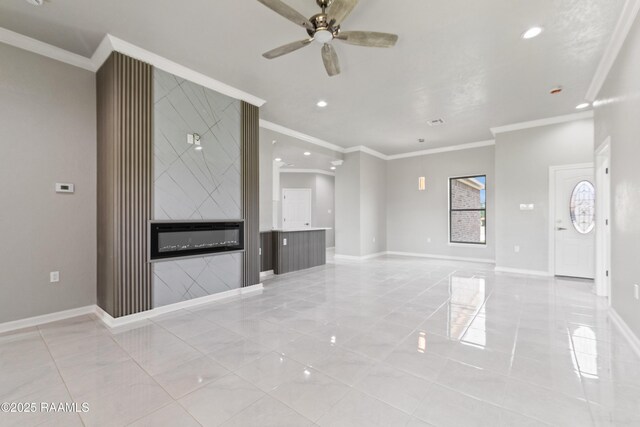 unfurnished living room with a ceiling fan, baseboards, and ornamental molding