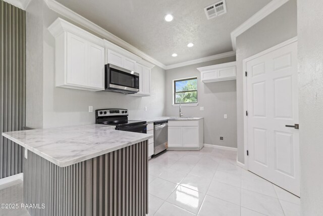 kitchen with a peninsula, a sink, visible vents, appliances with stainless steel finishes, and ornamental molding