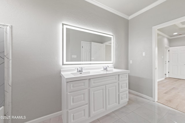 bathroom featuring tile patterned floors, a sink, double vanity, baseboards, and ornamental molding