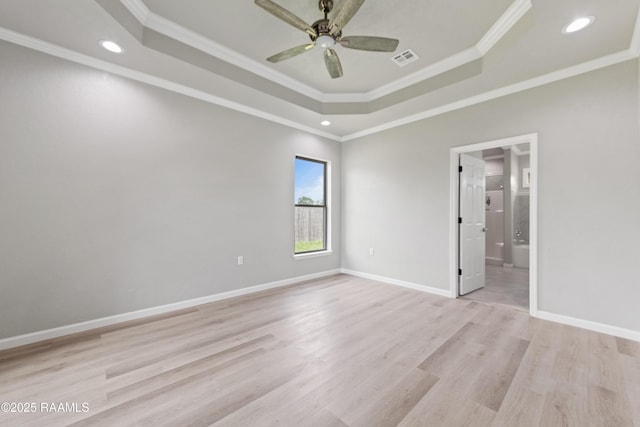 unfurnished bedroom with a tray ceiling, light wood-style flooring, and crown molding