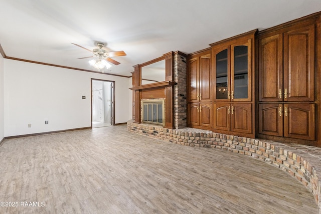 unfurnished living room with crown molding, a fireplace, and wood finished floors