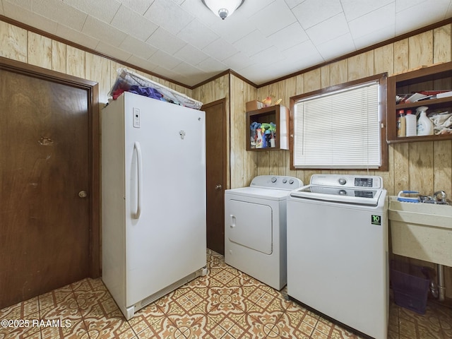 laundry area with laundry area, independent washer and dryer, and wooden walls