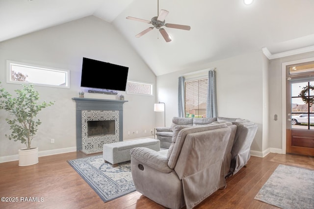 living area with ceiling fan, a fireplace, baseboards, and wood finished floors