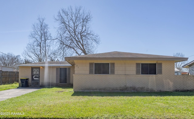 view of front of property with a front yard, brick siding, and fence