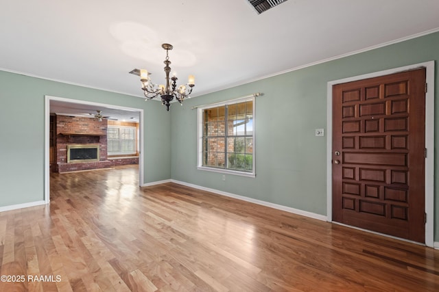 interior space featuring wood finished floors, a fireplace, and crown molding