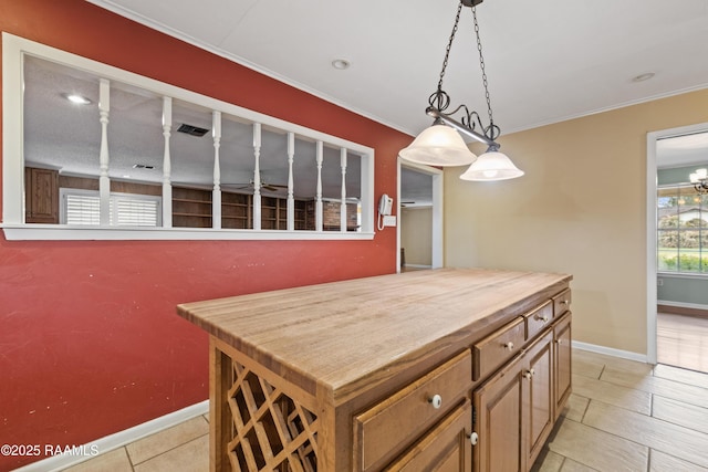 kitchen featuring butcher block counters, decorative light fixtures, baseboards, and ornamental molding