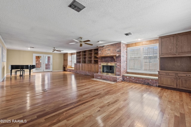 unfurnished living room featuring light wood-style floors, a fireplace, and visible vents